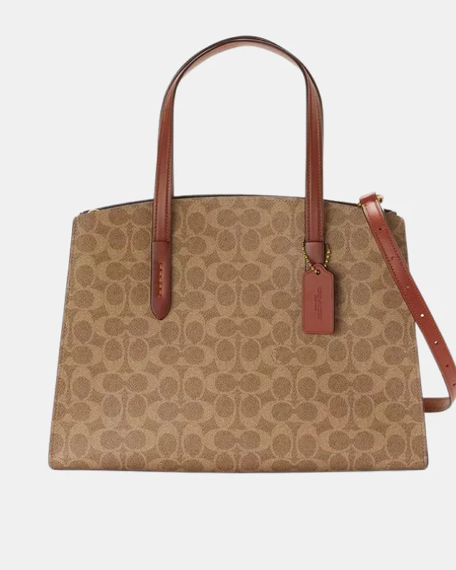 Coach tote bags with a snap - button closure and a decorative charm for styleCoach Signature Charlie Carryall Tote Bag